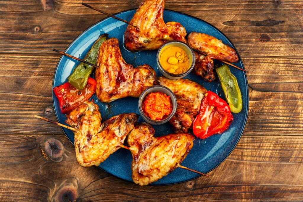 Grilled chicken wings and vegetables on skewers